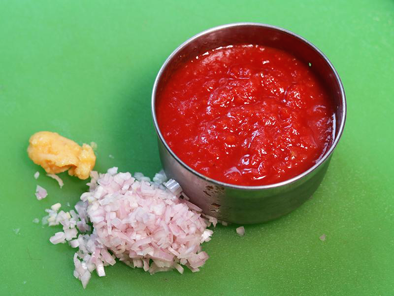 초록 도마에 다진 마늘, 다진 샬롯, 토마토 소스