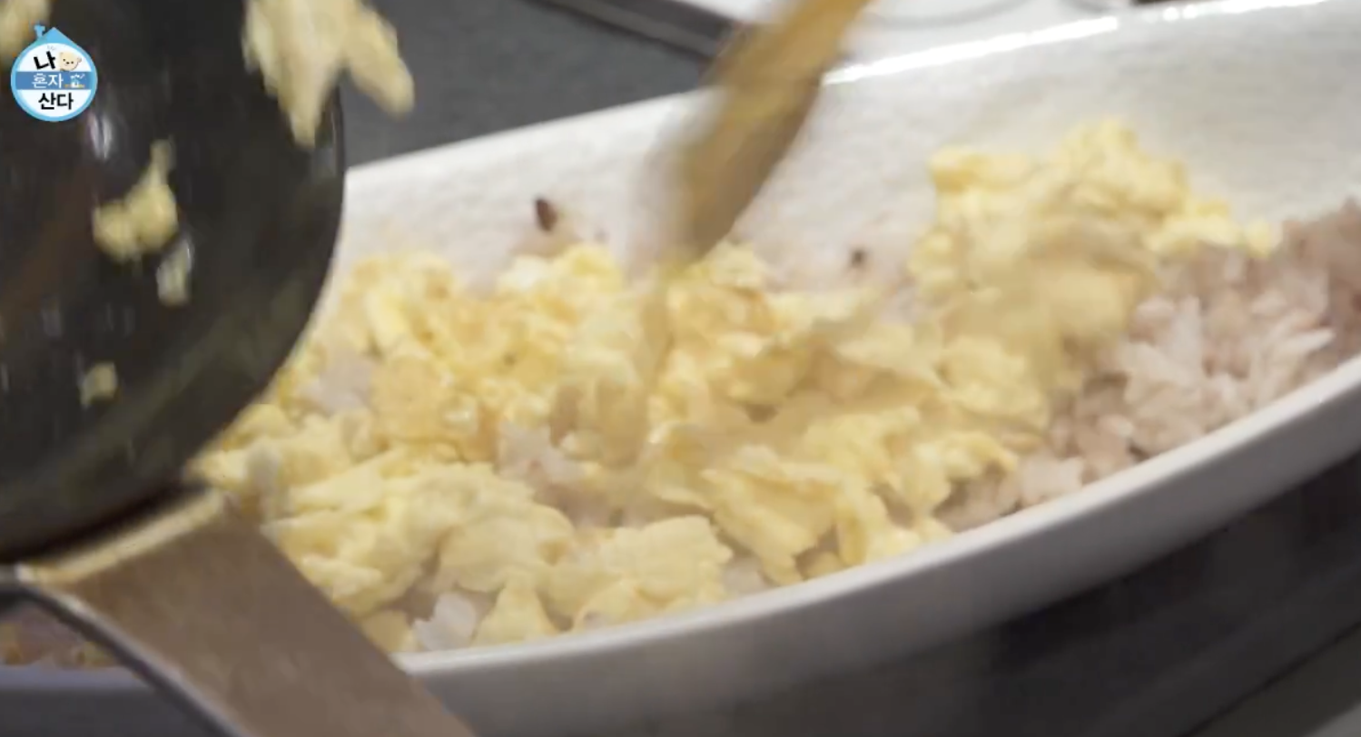 밥위에 스크램블을 얹는 모습