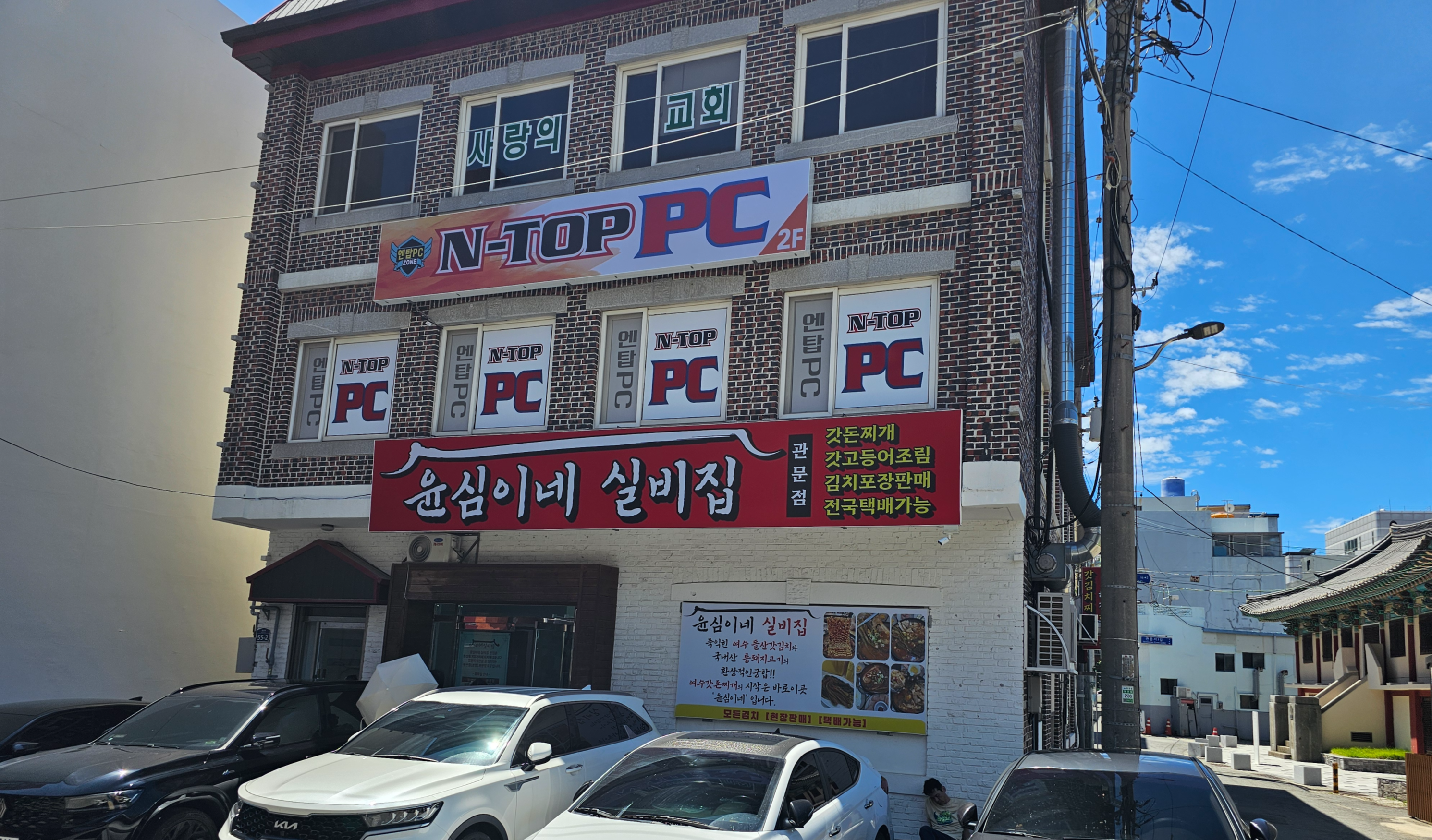 여수 윤심이네 실비집 외관, 붉은 간판이 걸린 건물 1층