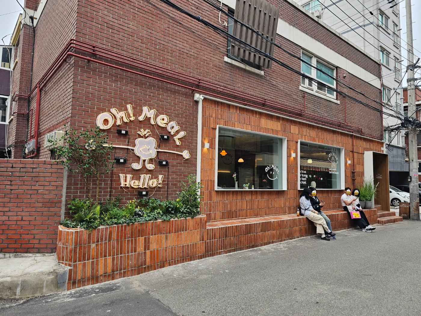성수 오밀 외관, 벽돌 건물과 귀여운 캐릭터 간판이 돋보이는 성수동 맛집