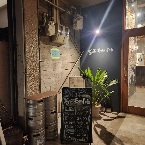 조명이 밝혀진 교토 비어 랩 전면, 칠판으로 만든 입간판이 보인다.