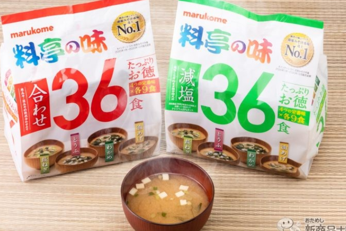 일본의 인스턴트 된장국의 상품 봉지 2개가 놓여져 있고 앞으로 조그만한 그릇에 된장국이 들어가 있다.