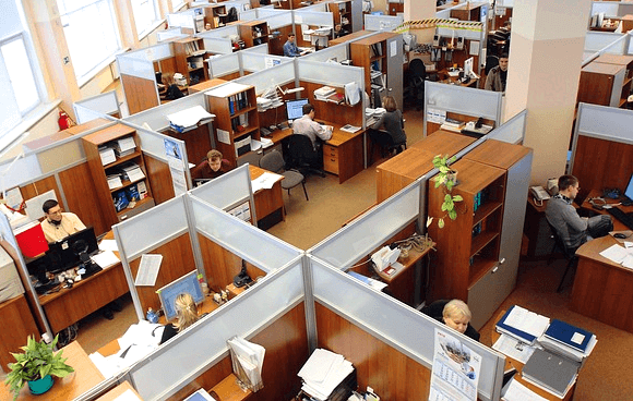 칸막이가 수십개 설치된 사무실 풍경으로 남자 직원들, 여자 직원들이 자신의 책상 앞에 앉아 열심히 일을 하고 있다.