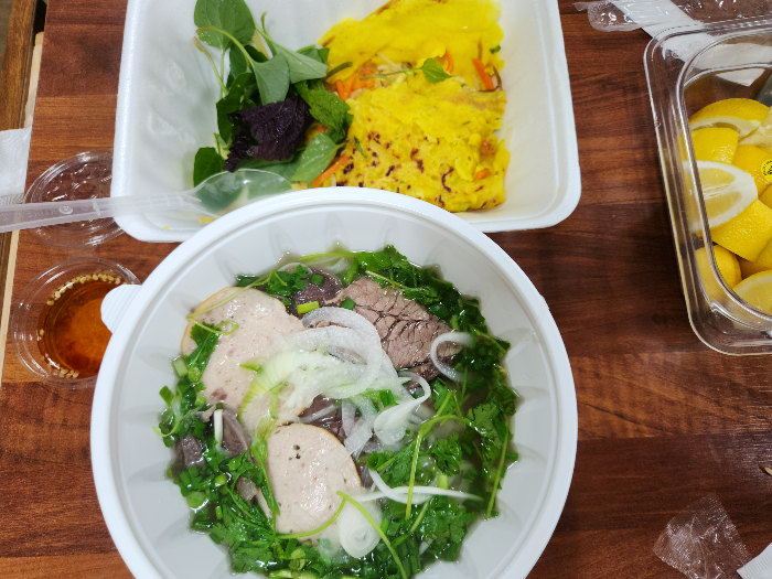 Bowls of banh xeo and rice noodles are on the table.