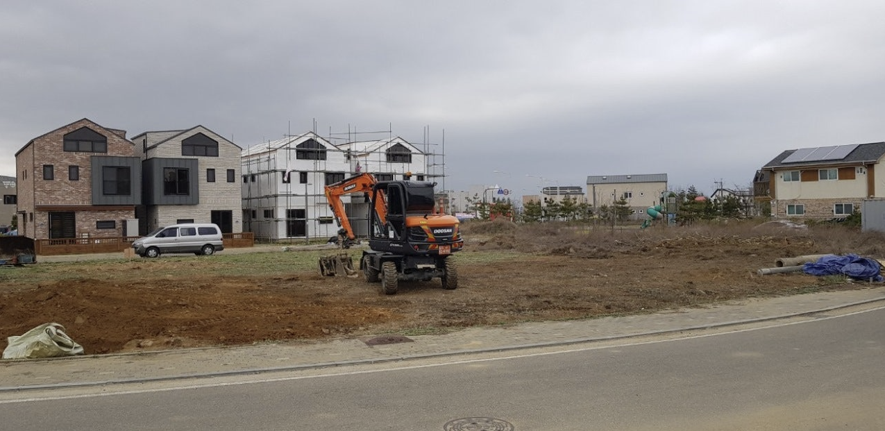 포크레인이 땅을 평탄화시키는 작업을 하고 있는 모습