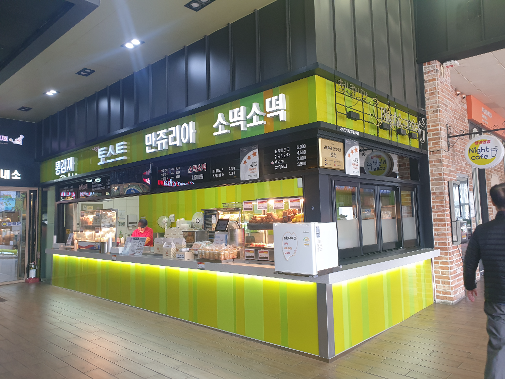 초록색 간판과 벽면을 가진 간식 코너