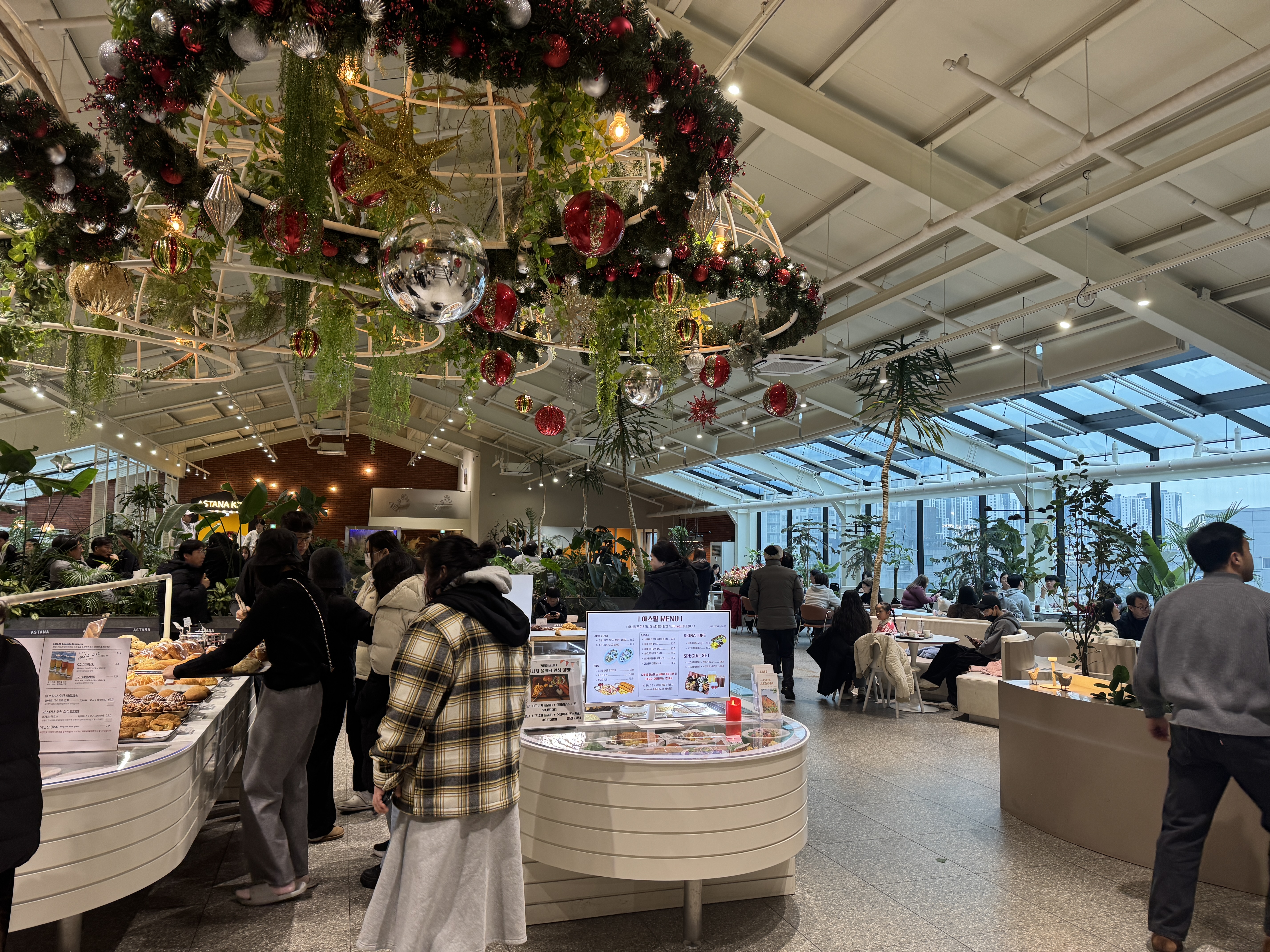 동탄 카페 아스타나 내부 전경, 크리스마스 장식과 식물이 많은 대형 카페의 주말 분위기