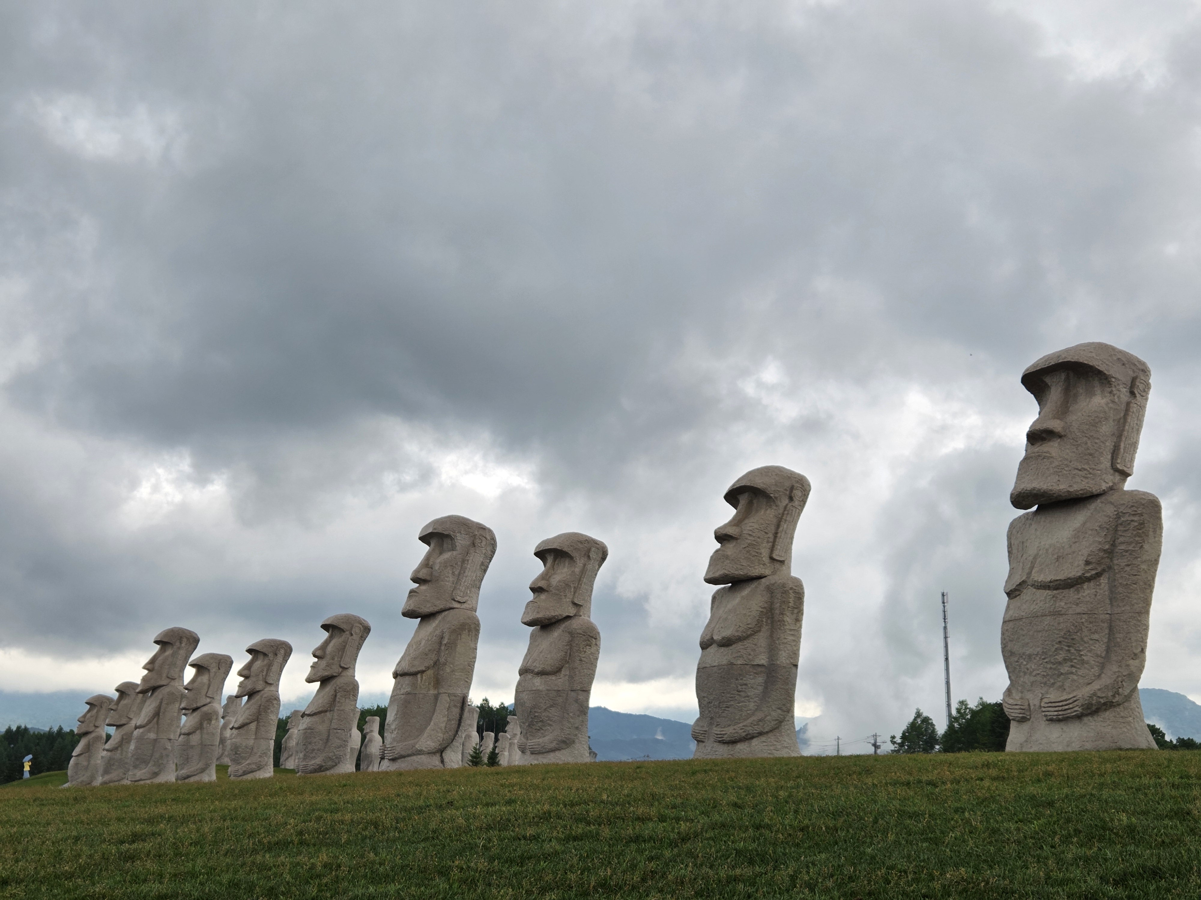 잔디밭에 줄지어 서 있는 모아이상 조각들