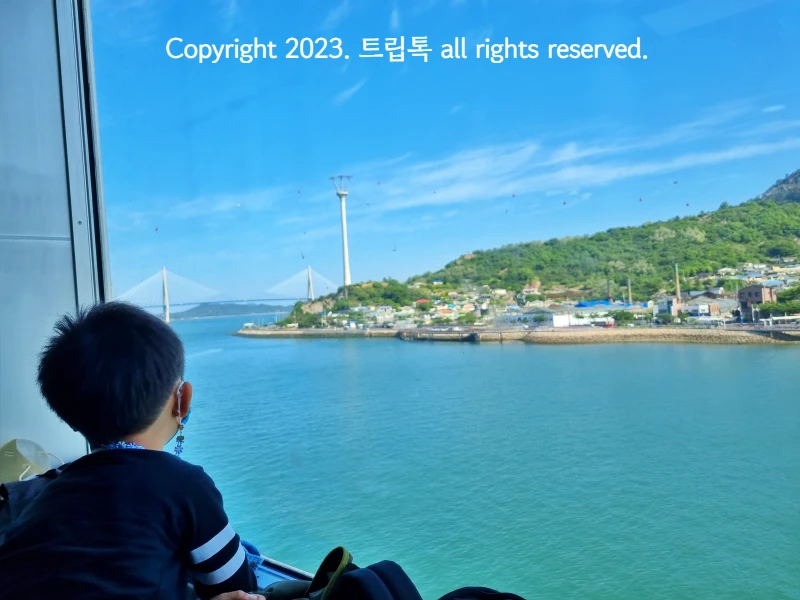 창밖으로 보이는 목포바다와 케이블카와 다리를 보는 아이