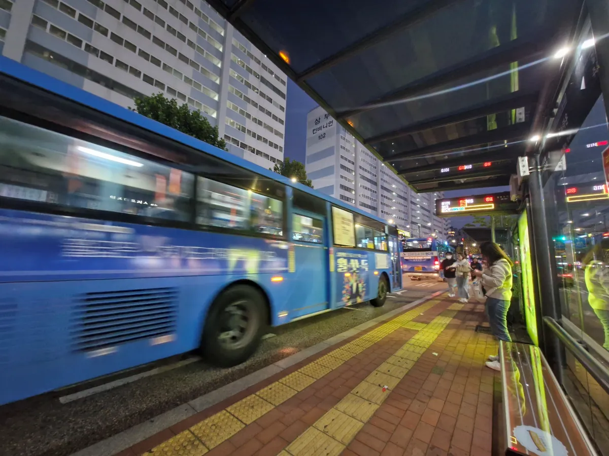 버스정류장에서-파란버스를-기다리고-있는-여성