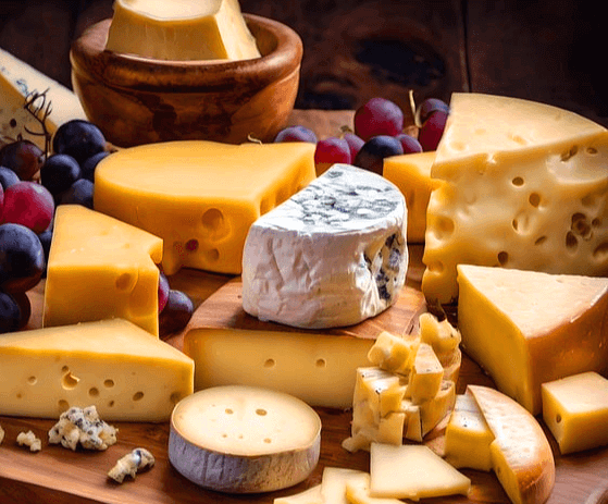 식탁에 커다란 치즈덩이들이 가득하다. 노란 치즈, 하얀 치즈들이다.