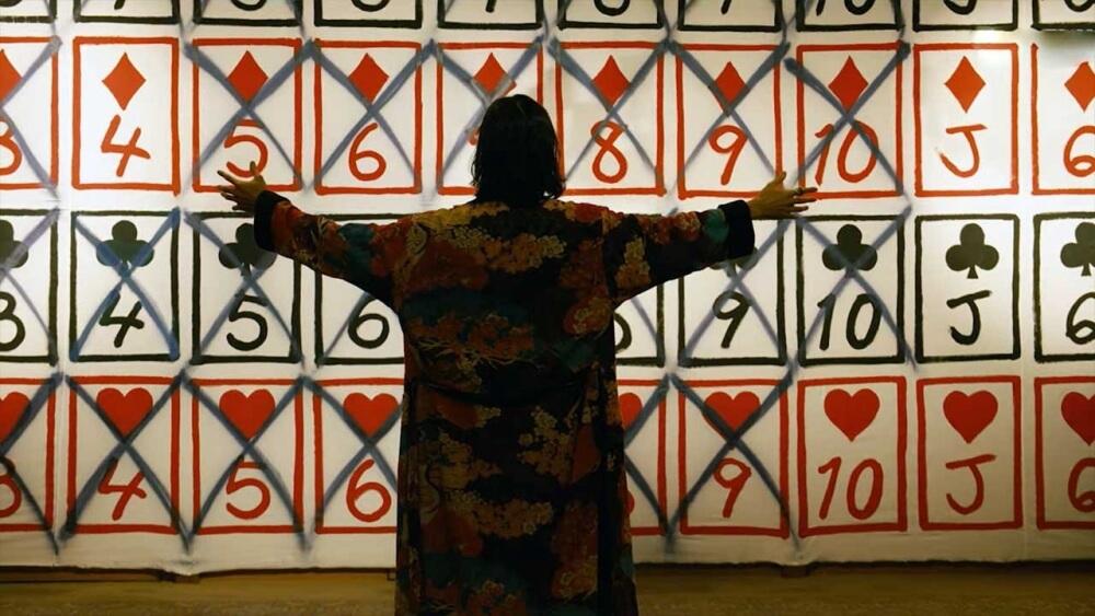 비치에서 트럼프가 그려진 벽면에 한 남자가 두팔벌려 서있다