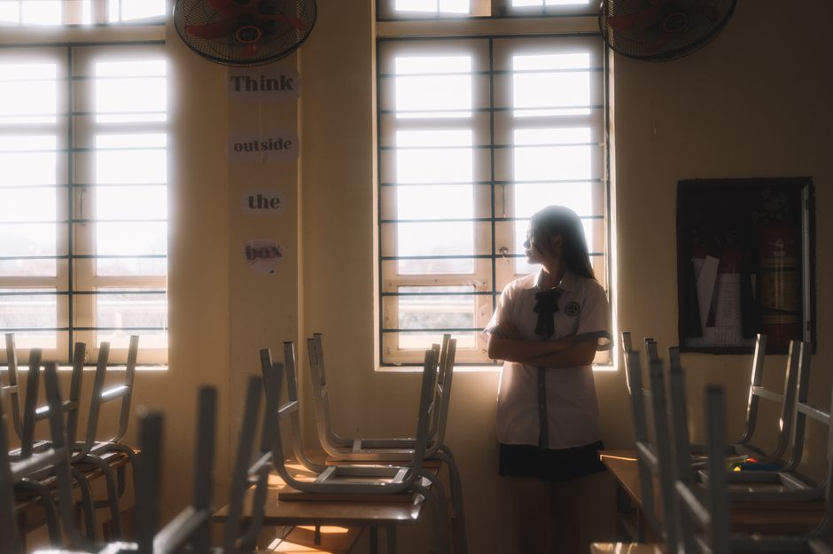 A thoughtful student looks out the window in a sunlit classroom in Lạng Sơn, Vietnam.