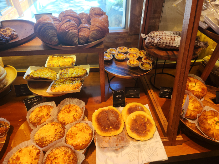Egg tarts, hotteok, and hamburger are on a plate.