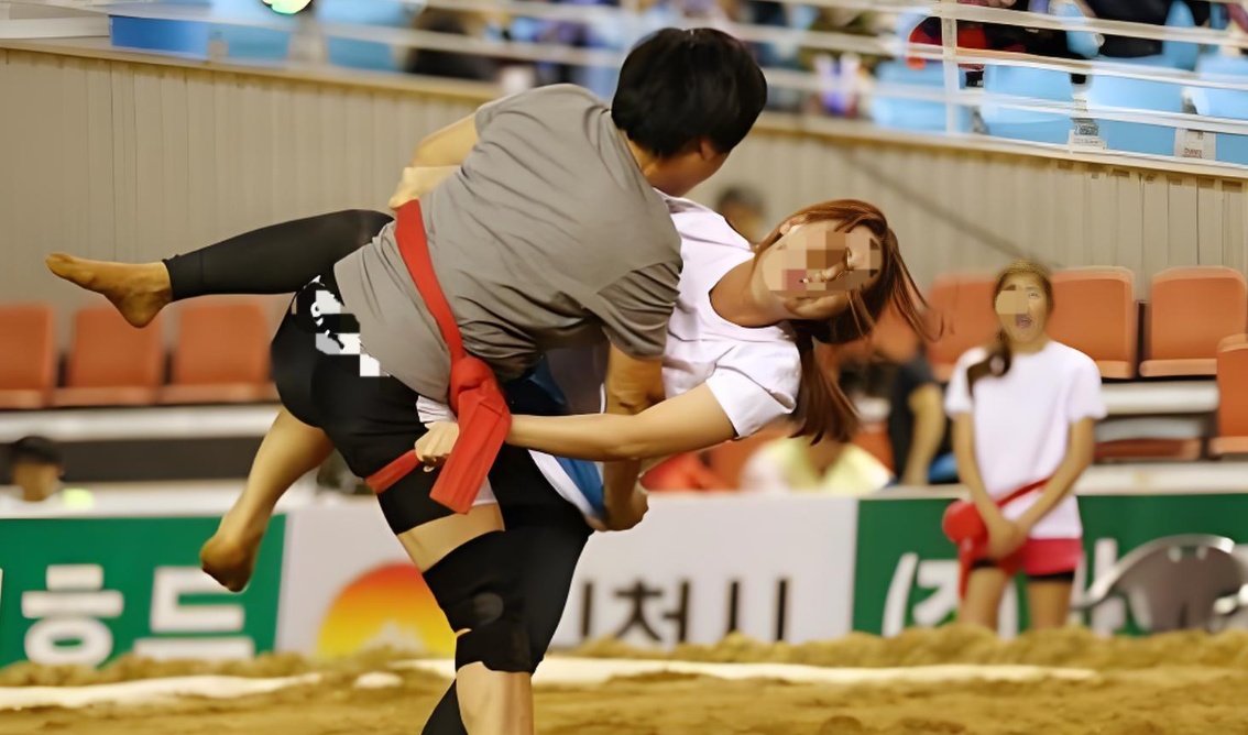 여자두명이모래판위에서씨름경기를하고있음