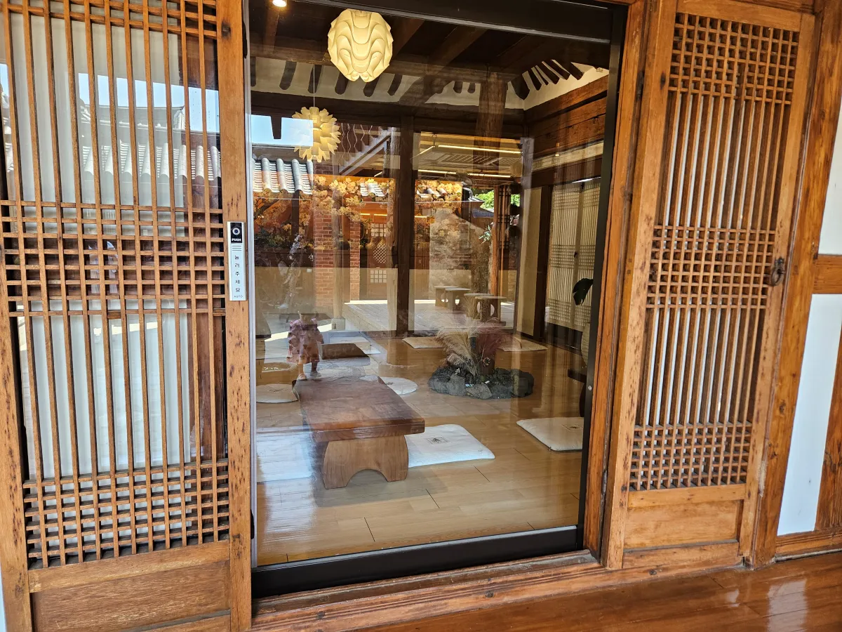 여러-테이블과-방석이-비치되어-있는-한옥-내부