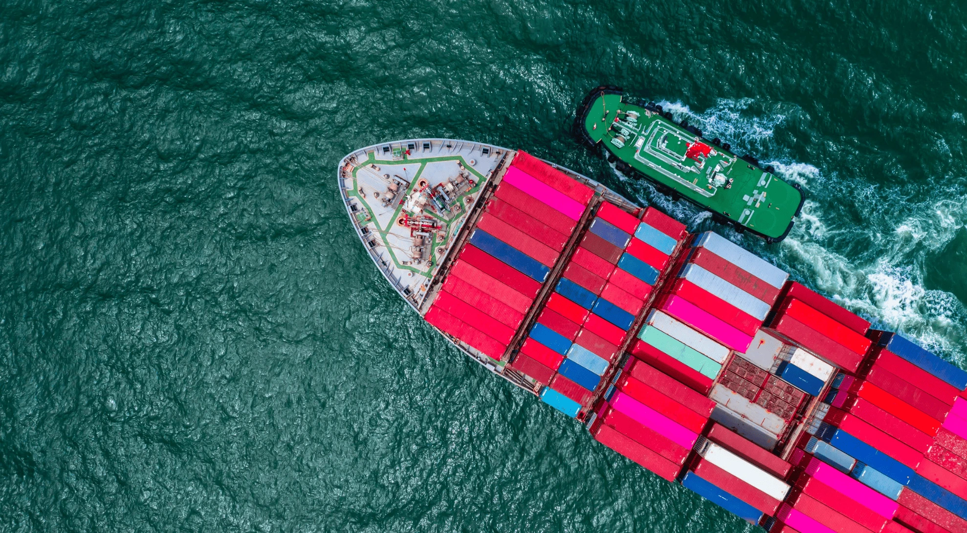 컨테이너선과 예인선이 함께 운항하는 모습으로, 대한조선이 주력하는 중대형 선박 건조 기술력을 보여주는 장면입니다.