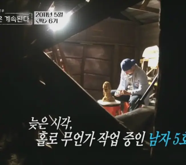 나솔사계- 어두운 작업실 파란색 모자를 뒤집어 쓰고 조각을 하고 있는 남자2호