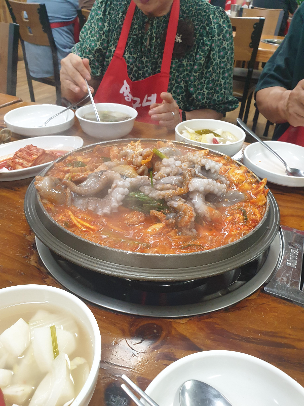 냄비 안에 산낙지가 들어가 있다 조개국 속 조개를 건지는 손님