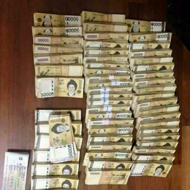 오 만원 지폐 다발이 가득하게 놓여 있는 사진