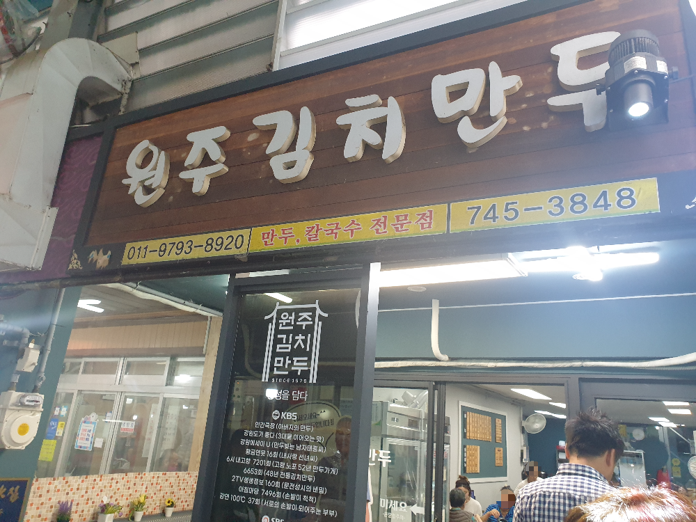 우드 간판에 상호와 전화번호가 있다.