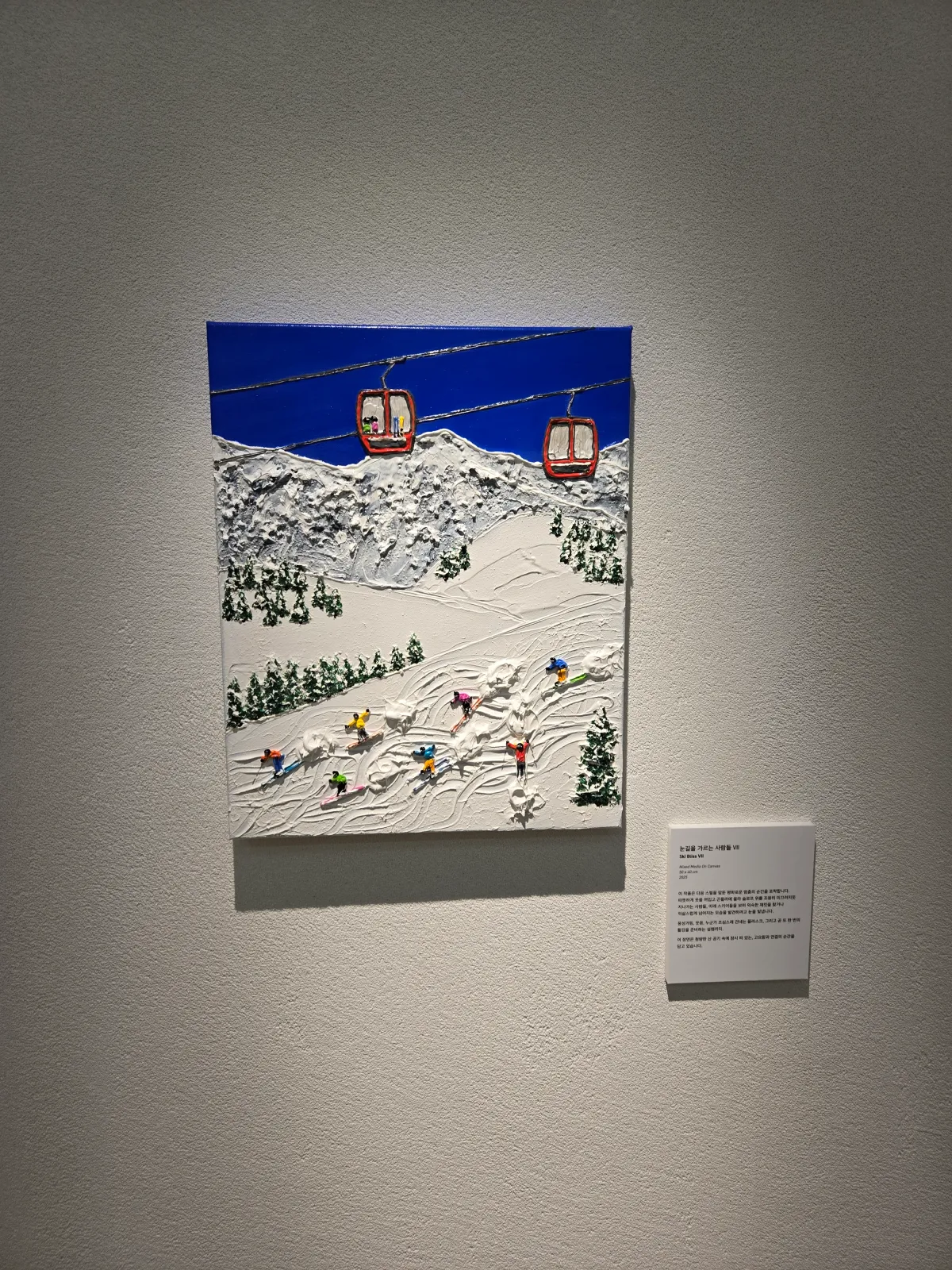 눈내린-산에서-스키를-즐기는-사람들과-그-위의-케이블카