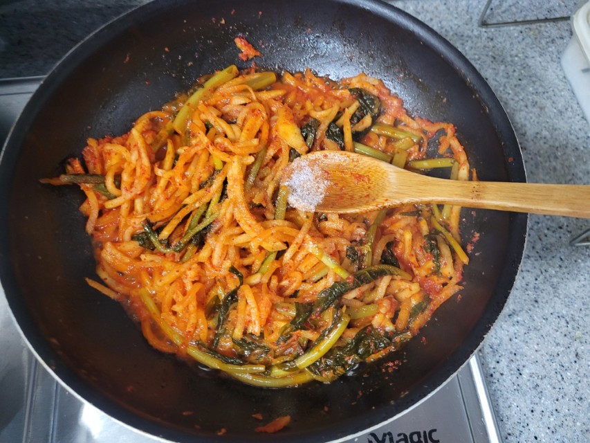 무채 볶음에 설탕을 넣는 모습