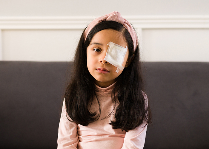 어린이가 눈다래끼가 있는 한쪽눈을 붕대로 가리고 있다