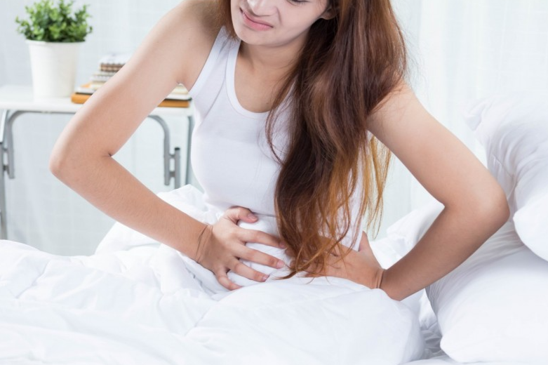 대장염으로 배를 쥐고 아파하는 여자의 모습