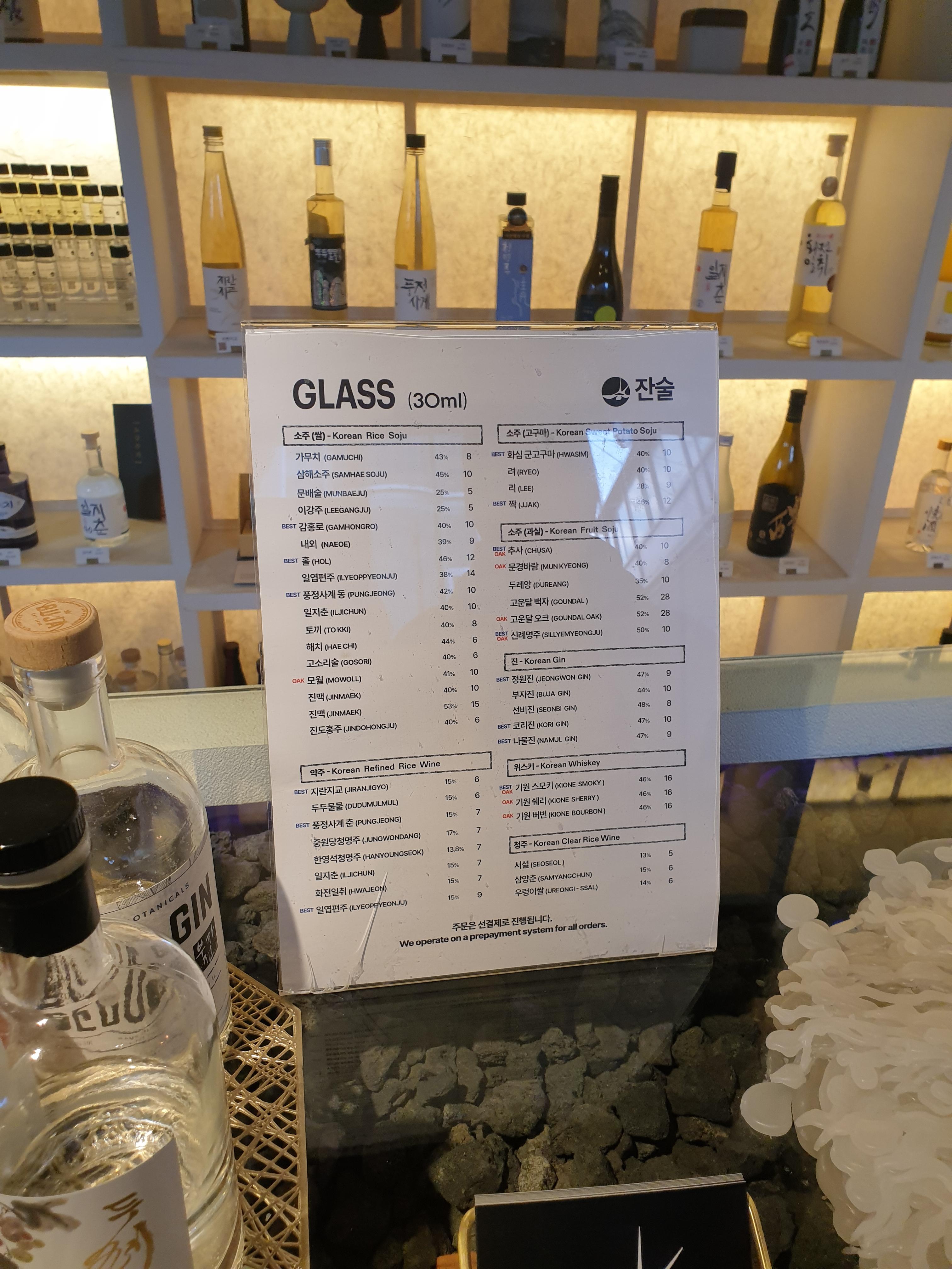 소주, 약주, 청주, 위스키, 진으로 구성된 메뉴판, 알코올 도수와 가격이 쓰여있다.