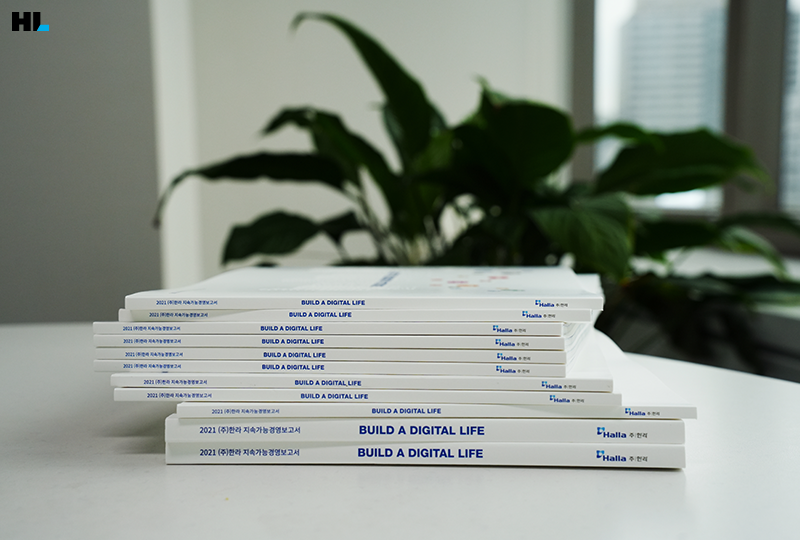 테이블 위 지속가능경영보고서가 쌓인 모습을 담은 이미지