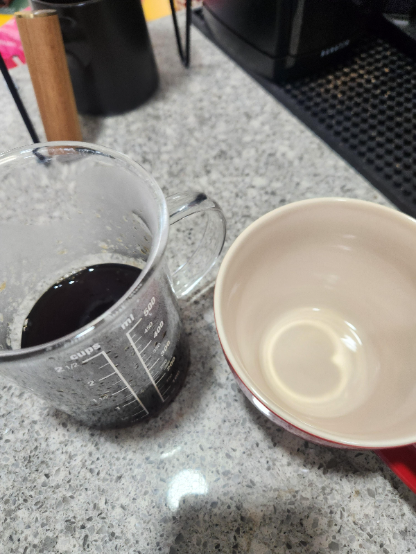 테이블 위에 추출된 커피가 담긴 서버와 빈 컵이 놓여있다.