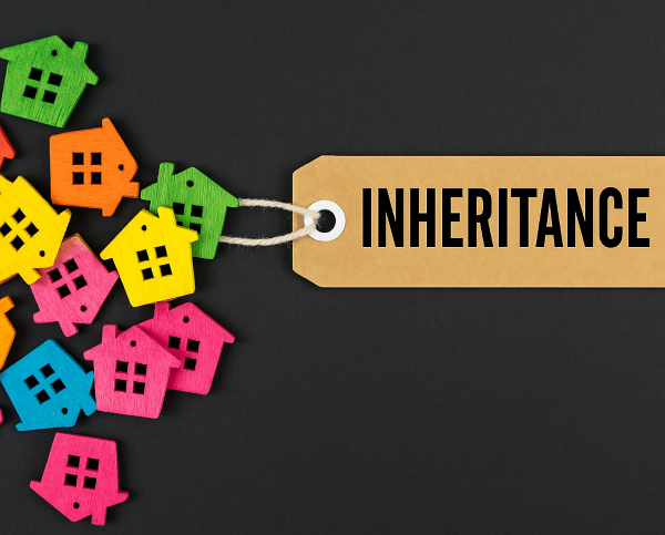 "검정 배경 위에 놓인 상속세(inheritance tax) 라벨과 알록달록한 집 모양 아이콘들"