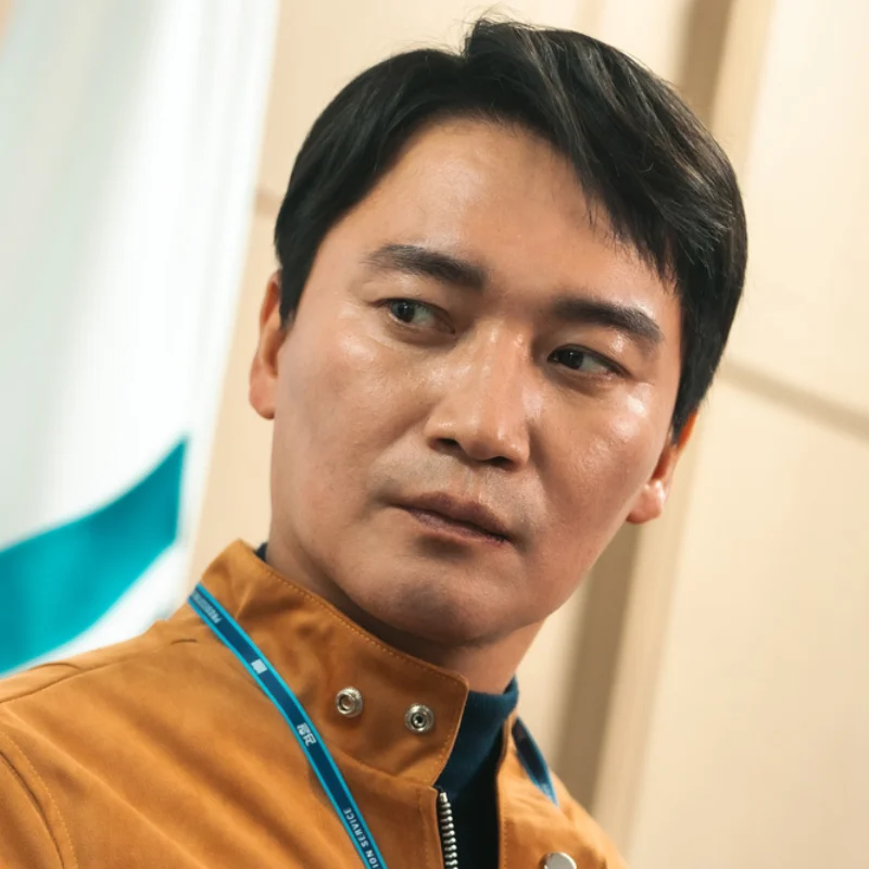 어느 사무실을 배경으로 노란 상의에 경찰 신분증을 매고 서 있는 드라마 7인의 탈출의 남철우 캐릭터