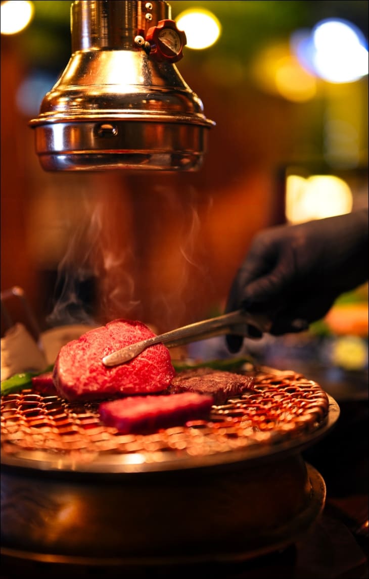 직원이-장갑을-끼고-소고기를-굽고-있다.