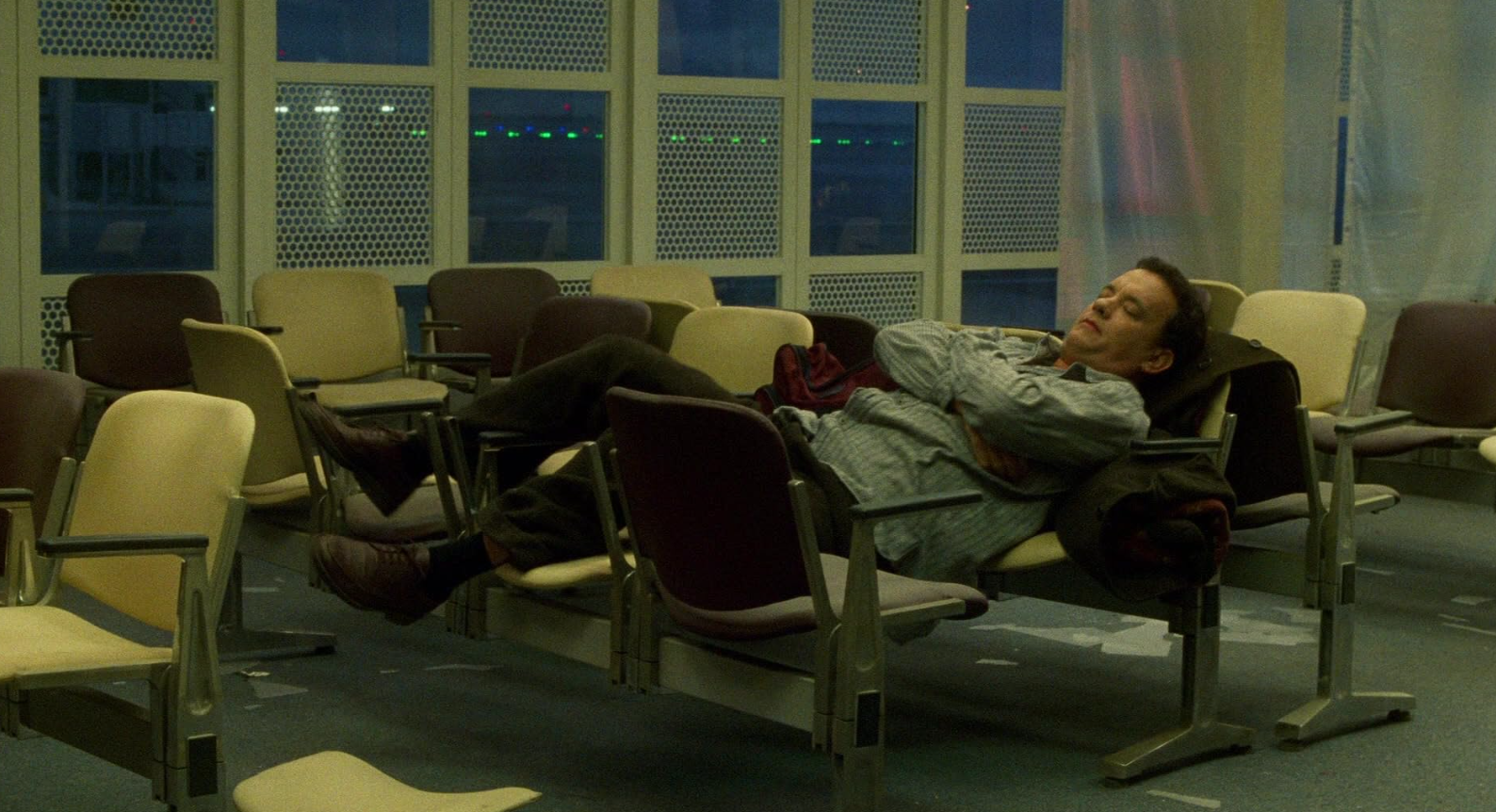 공항의자를 재배치해서 침대로 사용하는 주인공