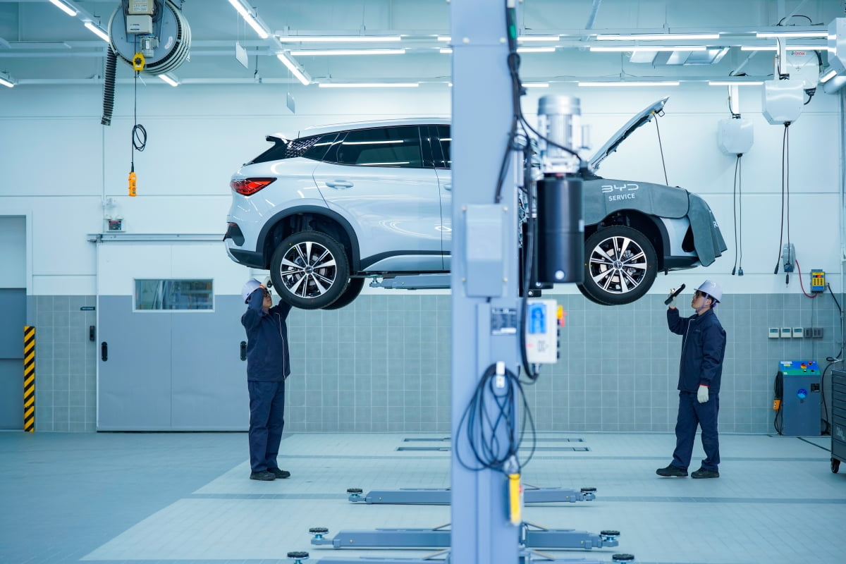 BYD의 정비사들이 차량 하단 부분을 점검하고 있다.