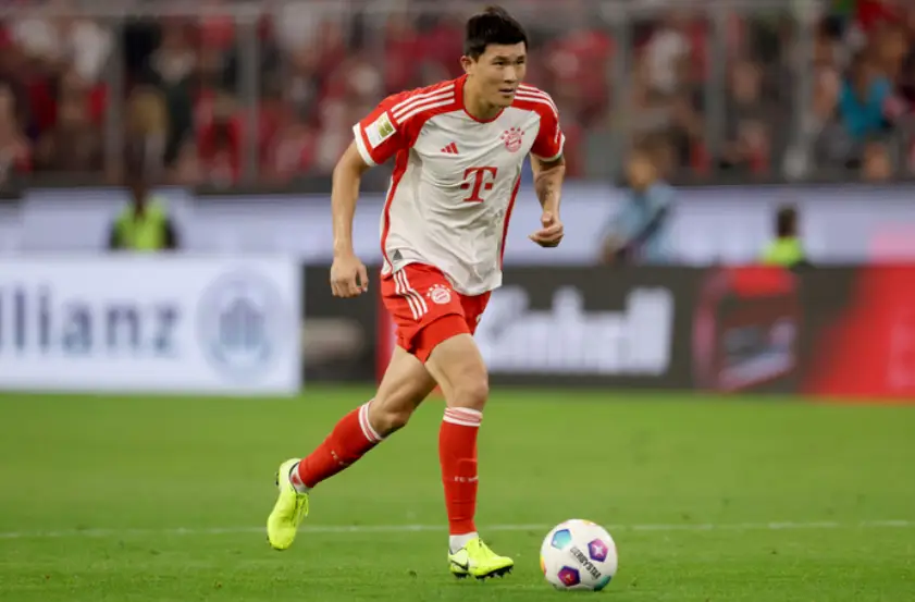 손흥민 연봉-
초롯색 축구장 꽉찬 관중석 빨간생 양말 빨간색 반바지 흰색과 빨간색이 교차된 바이에뮌헨 유니폼을 입고 흰색 축구공을 차며 달리는 김민재