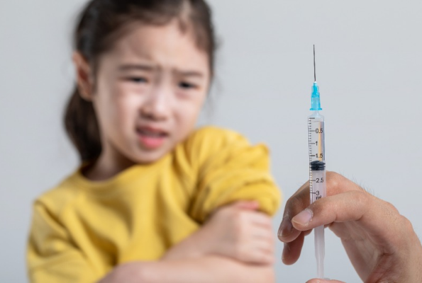 두려워하는 여자 아이와 백신주사