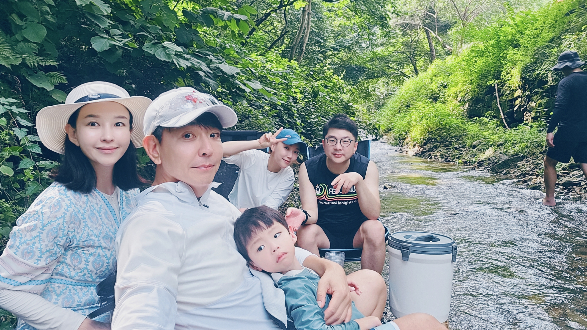 캠핑장내 계곡에서 가족들이 사진을 찍고 있습니다.