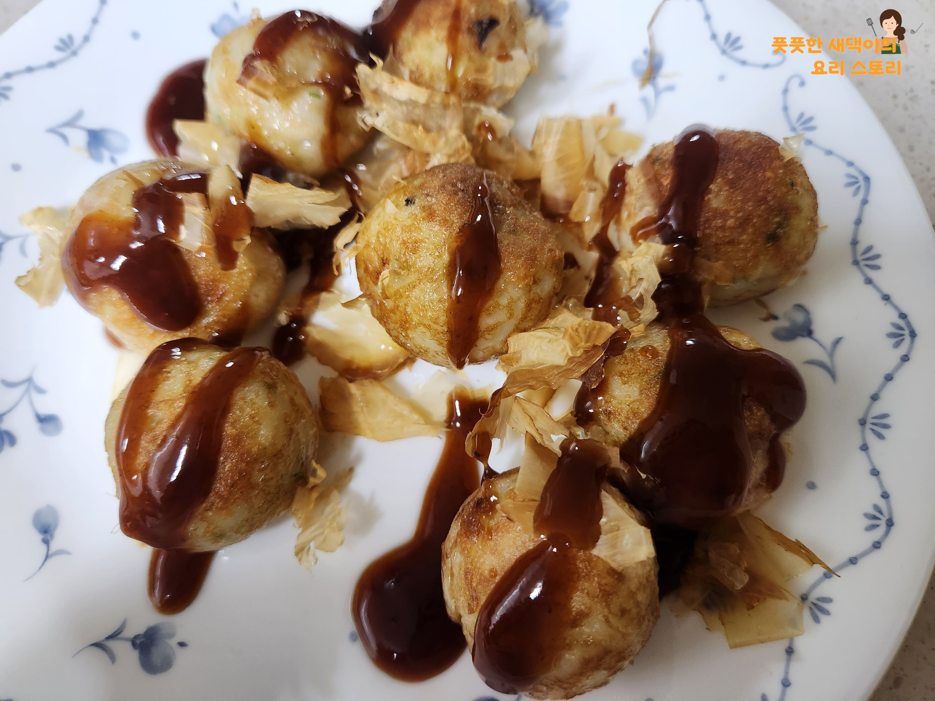 익은 타코야끼 위에 소스 뿌리기