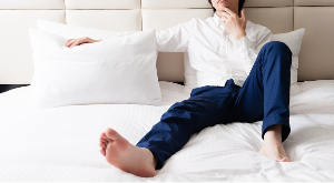 침대에 앉아있는 남성