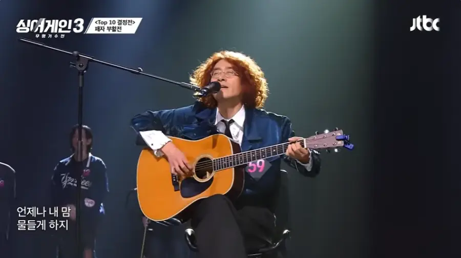 싱어게인3-
노란곱슬머리 파란자켓 노란통키타 검은바지 검은의자에 앉아 스탠딩마이크에 노래하는 59호