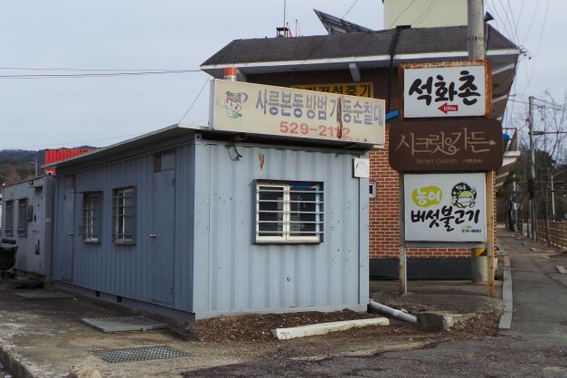 석화촌 입구 화살표, 야래는 버섯불고기 간판, 왼쪽엔 콘테이너 하우스,