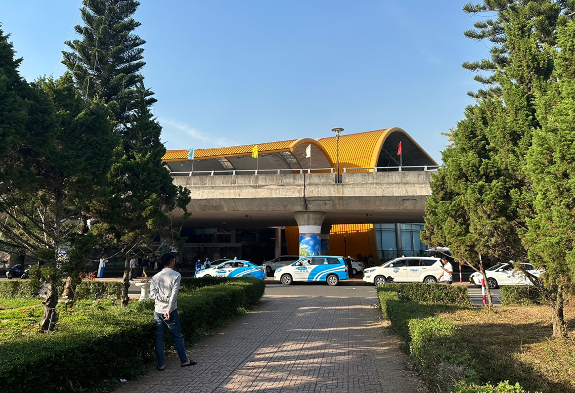 달랏 리엔크엉 공항 전경, 공항 앞쪽에 택시들이 있고 그랩 탑승