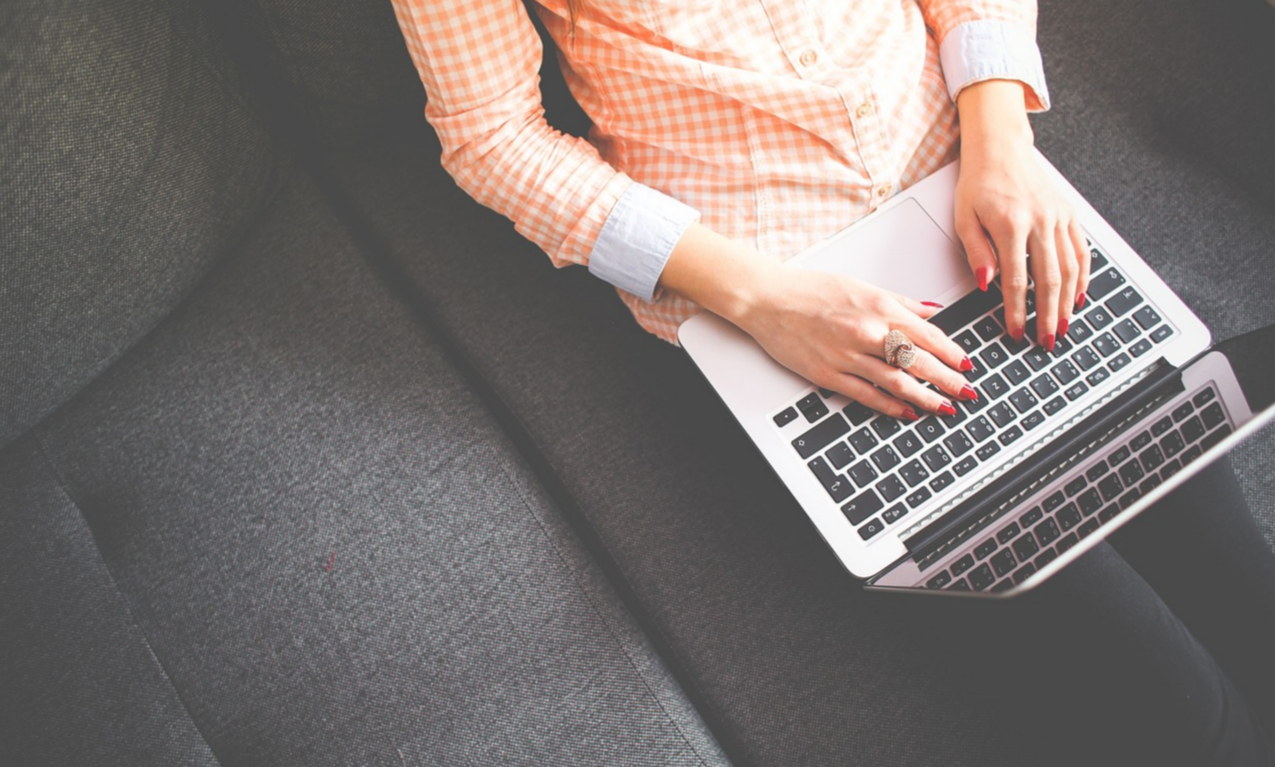 한-여성이-소파에-앉아-노트북을-사용하고-있는-모습이다.