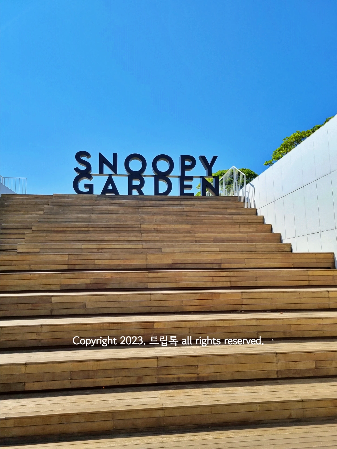 계단 위에 검정색 조형물로 영어로 스누피가든이라고 적혀있다.