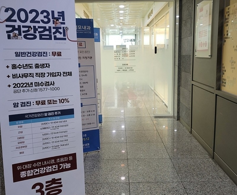 병원 출입구 앞에 2023년 건강검진 관련 내용이 안내되어 있다.