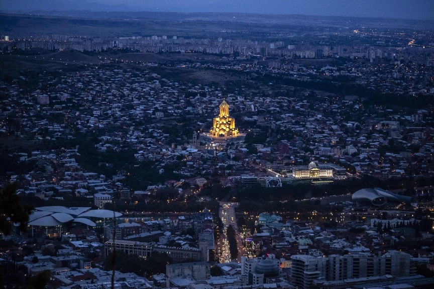 조지아 트빌리시 야경 속에서 조명에 비친 성 삼위일체 대성당과 도시 전경