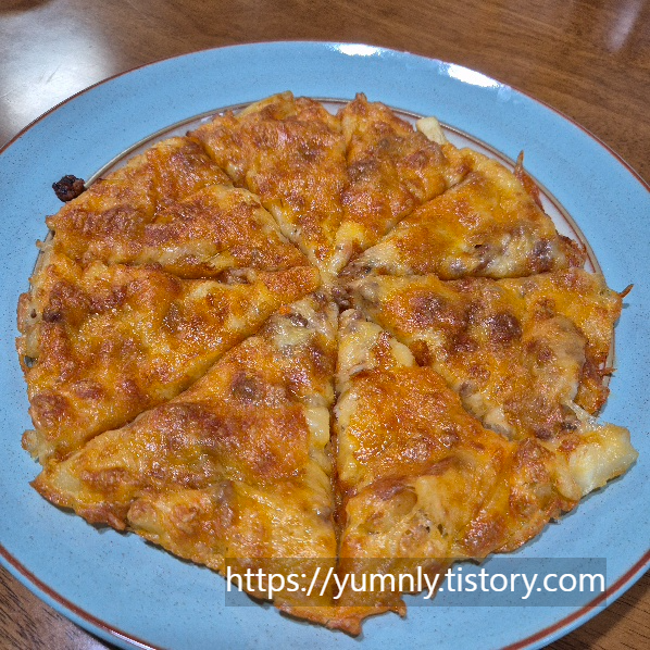 A close-up of a slice of french fry pizza showing melted cheese and tomato sauce